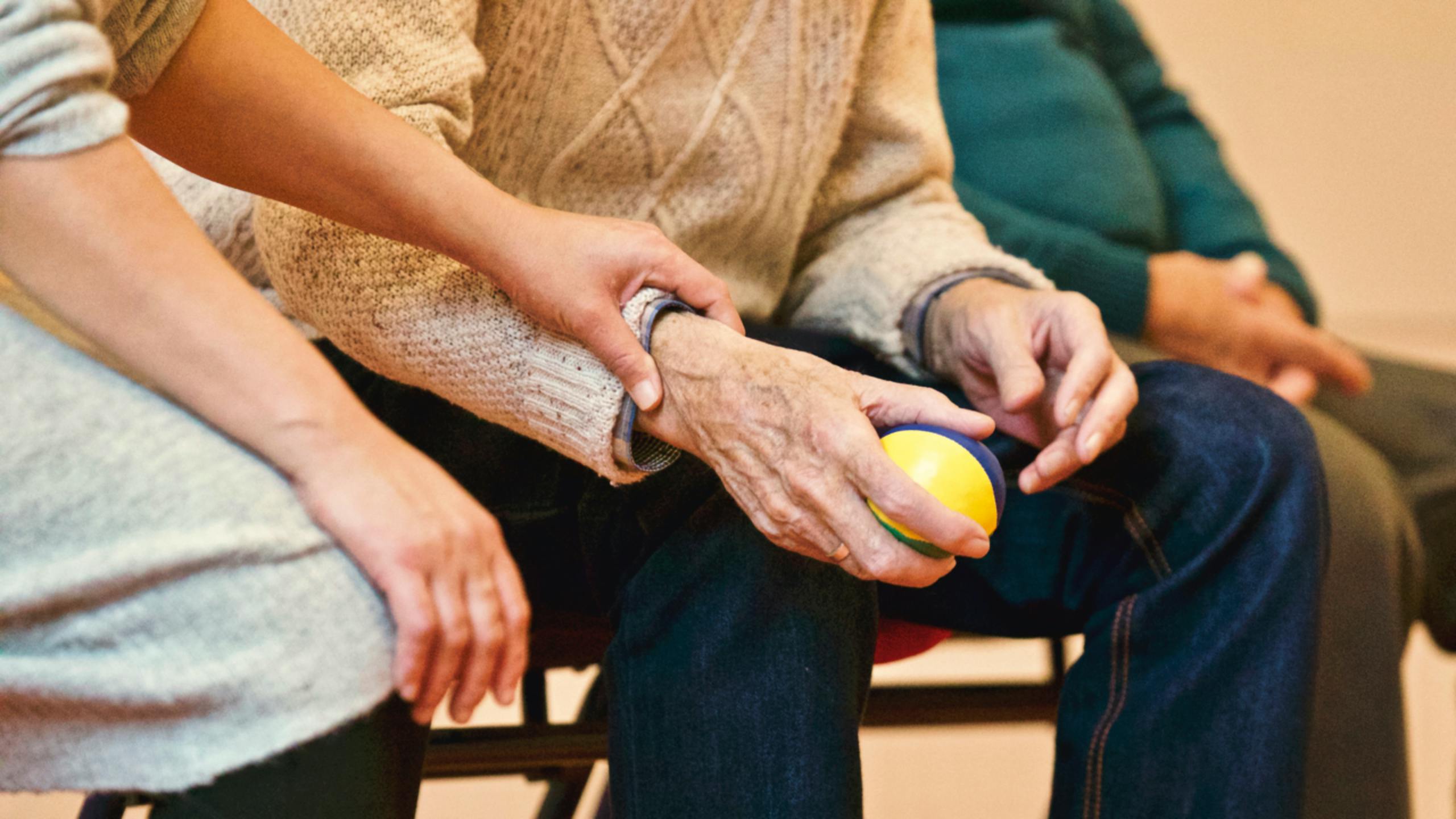 Professional caregiver holding hands with elderly patient, showing compassionate care